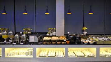 Una mesa de buffet con diversos alimentos y utensilios.