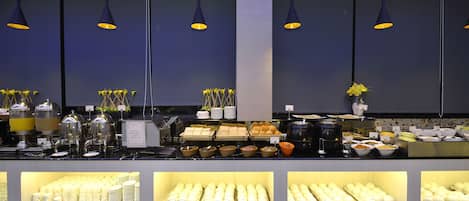 Un buffet proposant une variété de plats et d’ustensiles.