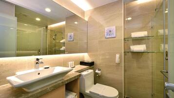 A modern bathroom with a glass shower enclosure, a sink, and a toilet.