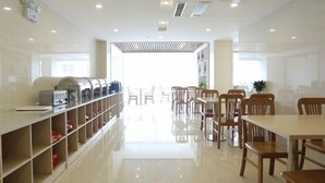 Un comedor moderno con una barra larga, varias mesas y sillas.