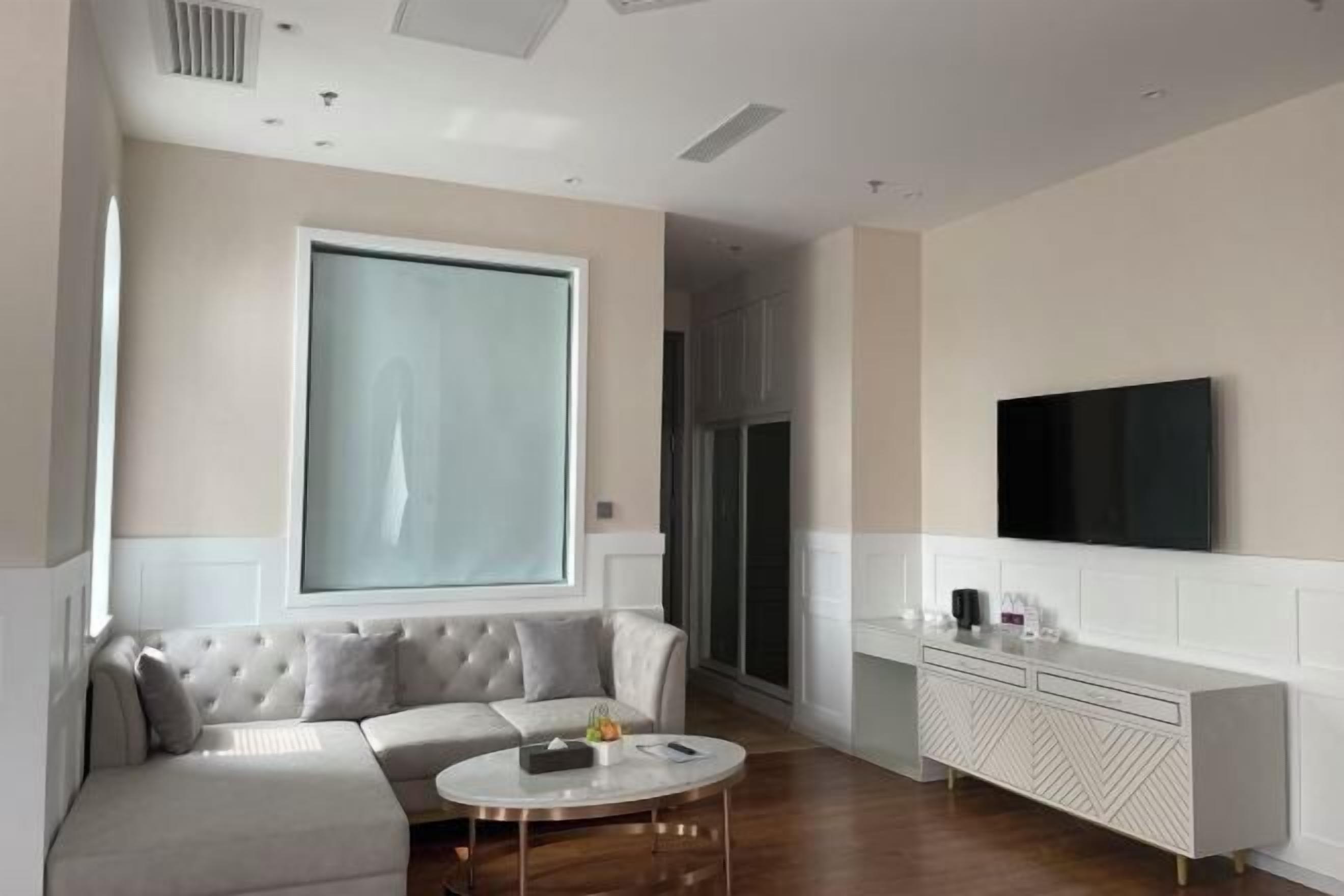 A modern living room with a sofa, a coffee table, a TV, and a cabinet.