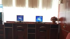 A hotel lobby with a reception desk, two computer monitors, a red sofa, and a glass coffee table. - Hanting Hotel Shanghai Zhongshan West Road (Shanghai)