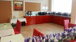 A hotel lobby with a reception desk, a painting on the wall, and a buffet area with food containers. - Hanting Hotel Shanghai Zhongshan West Road (Shanghai)