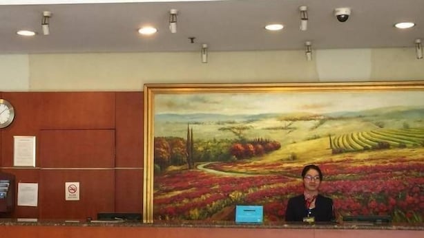 A reception desk with a large landscape painting, a clock, and a sign with a no smoking symbol. - Hanting Hotel Shanghai Zhongshan West Road (Shanghai)