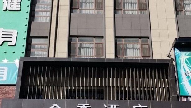 A hotel with a modern facade, featuring a prominent sign with the name 'JI HOTEL' in both Chinese and English.