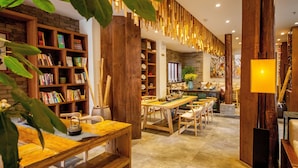 A cozy library with wooden bookshelves, a dining area with a long table, and a warm, inviting atmosphere. - Liman Wenzhi No.1 Hotel Lijiang Ancient Town (Lijiang)