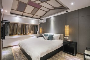 A modern hotel room with a large bed, a window with curtains, a bedside table, and a wall-mounted air conditioner. - Liman Wenzhi No.1 Hotel Lijiang Ancient Town (Lijiang)