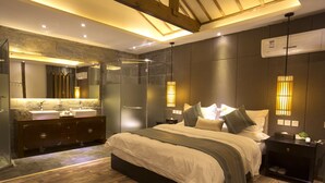 A modern bedroom with a large bed, a vanity with a mirror, and a walk-in shower. - Liman Wenzhi No.1 Hotel Lijiang Ancient Town (Lijiang)