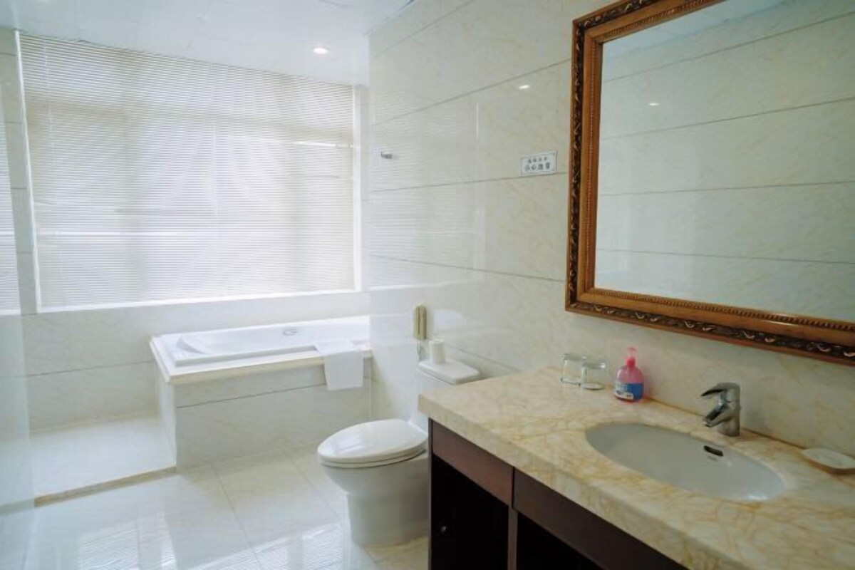 A modern bathroom with a bathtub, toilet, and sink.