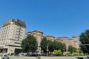 Un edificio de varios pisos con fachada plana y entrada en esquina.