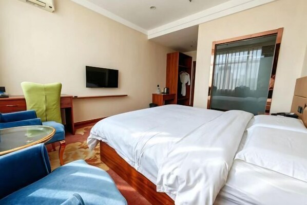 A hotel room with a bed, a TV, a desk, and a chair. - Run Zeng Hotel (Dandong)