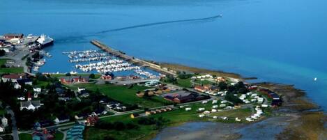 An aerial view of a coastal town with a marina, houses, and a small harbor.