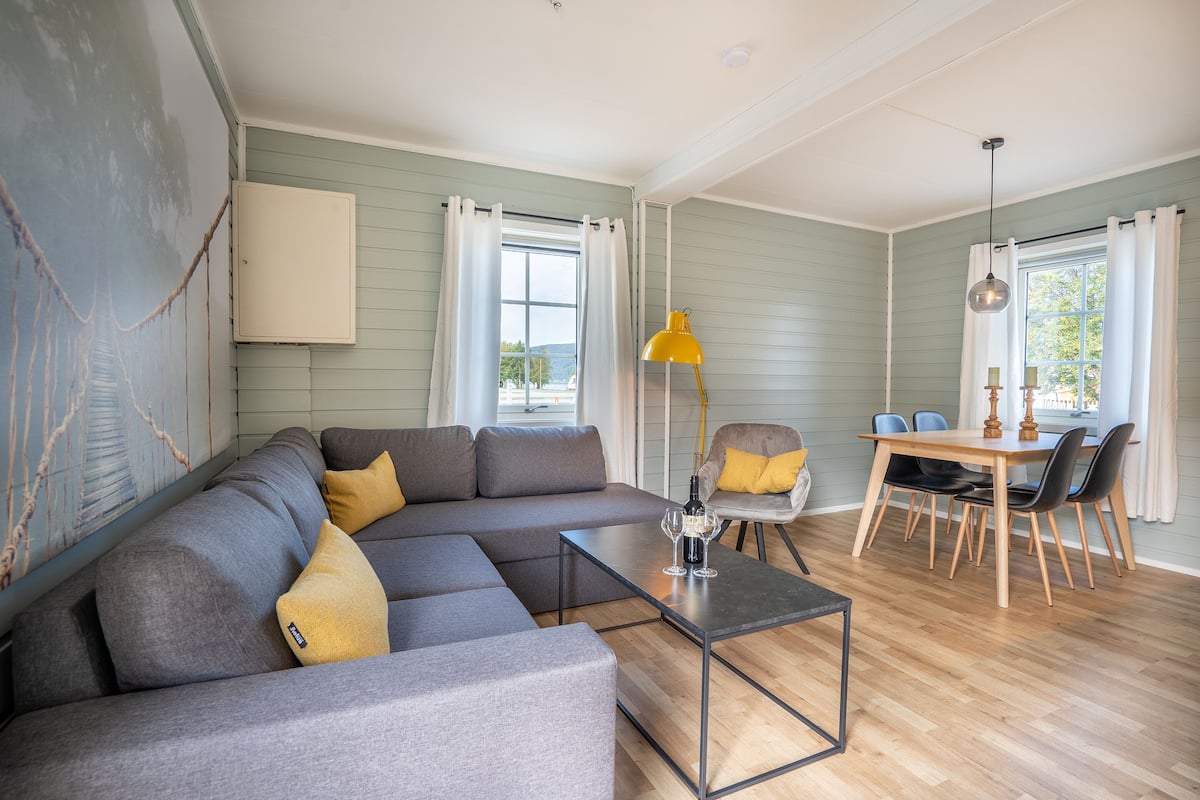 A living room with a sectional sofa, a dining table with chairs, and a coffee table.