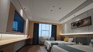 Ein Hotelzimmer mit einer Küchenzeile, zwei Betten, einem Schreibtisch und einem großen Fenster.