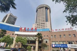A multi-story building with a prominent entrance and signage. - Goubin Hotel (Gushi)