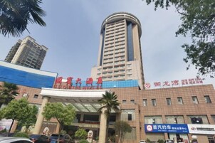 Un edificio de varios pisos con una entrada destacada y señalización.
