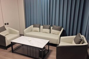 A modern living room with a sofa set, a coffee table, and a side table.