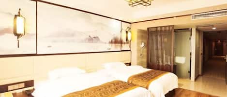 A hotel room with two beds, a large painting on the wall, and a modern chandelier.
