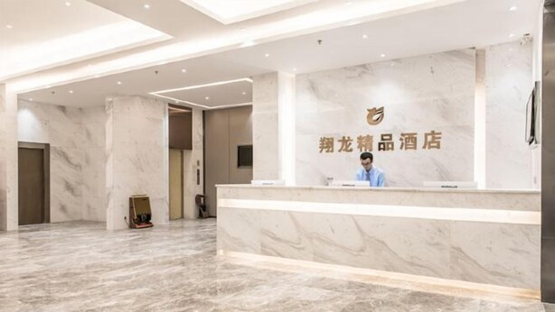 A hotel reception area with a marble floor, a reception desk, and a sign with Chinese characters. - Xianglong Boutique Hotel (Guangzhou North Railway Station Huacheng Road Subway Station) (Guangzhou)