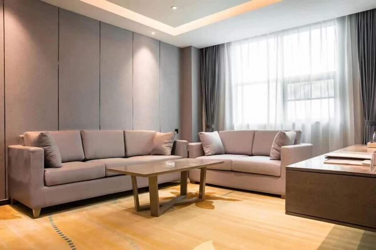 Een moderne woonkamer met een zithoek, een salontafel en een bijzettafeltje.