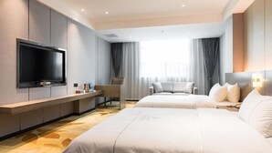 A hotel room with a large flat-screen TV, two beds, a desk, and a chair. - Xianglong Boutique Hotel (Guangzhou North Railway Station Huacheng Road Subway Station) (Guangzhou)