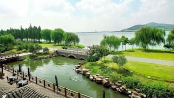 A riverside view with a bridge, grassy areas, and a paved path.