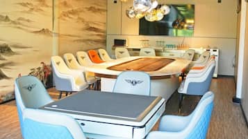 A modern dining area with a round table, multiple chairs, and a laptop on the table.