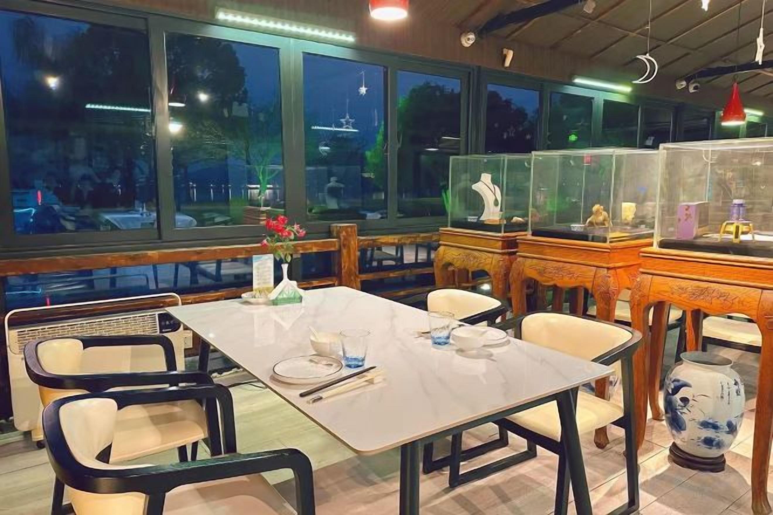 A restaurant with a table set for two, chairs, and decorative items.