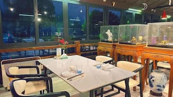A restaurant with a table set for two, chairs, and decorative items.