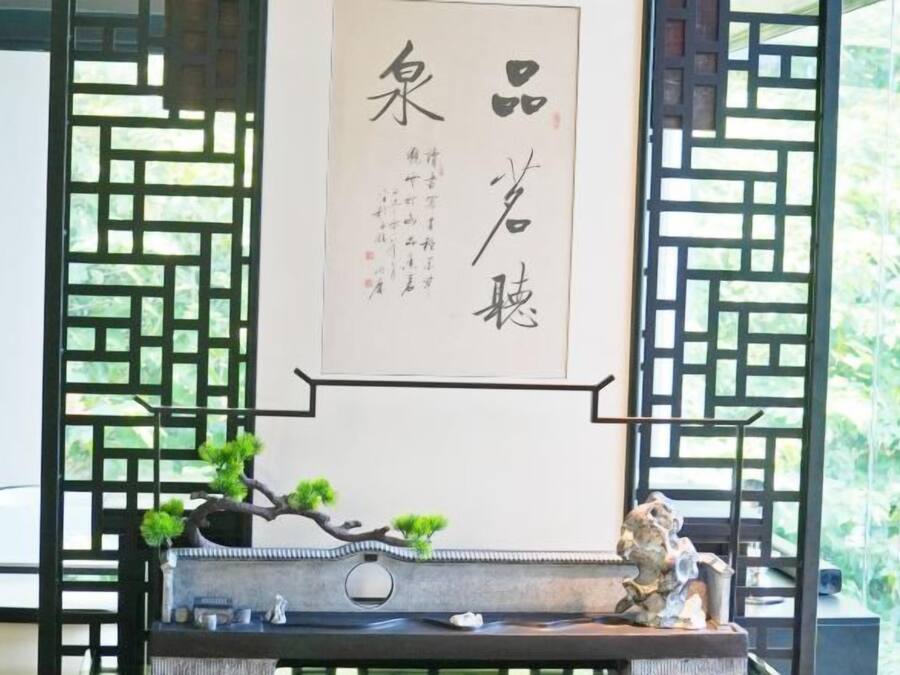 Une pièce de style japonais traditionnel, avec un sol recouvert de tatamis, un paravent en papier de riz (shoji) et un rouleau calligraphié suspendu au mur.