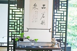 A traditional Japanese room with tatami flooring, a shoji screen, and a hanging scroll with calligraphy. - 1881 Peninsula Hotel (Wuxi)