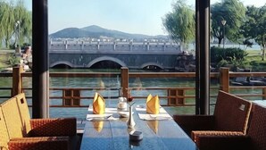 Une table dressée pour deux personnes, avec vue sur un pont et une rivière.