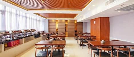 Restaurante com várias mesas e cadeiras, espaço para buffet e design de teto moderno.