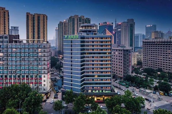 Een hoog hotel met meerdere verdiepingen, een opvallende ingang en een uitzicht op de omliggende stad.