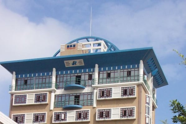 A multi-story building with a blue roof and a sign indicating it is a hotel.