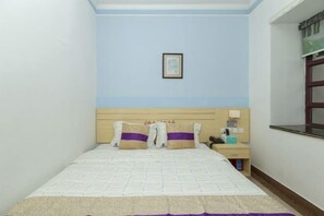 A small, neatly arranged bedroom with a single bed, a nightstand, and a wall-mounted shelf. - Fengju Business Hotel (Hourui Metro Station, Shenzhen Airport) (Shenzhen)