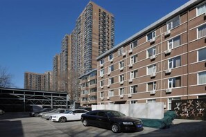 A multi-story residential building with a parking area in front. - Guijing Business Hotel (Beijing)