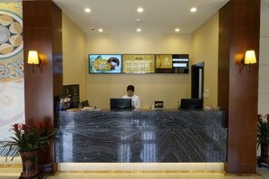 A reception desk with a marble top, a digital screen, and a person behind it. - Guijing Business Hotel (Beijing)