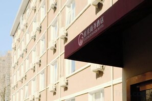 Un edificio de hotel con múltiples ventanas y un cartel que indica que es un hotel para negocios.