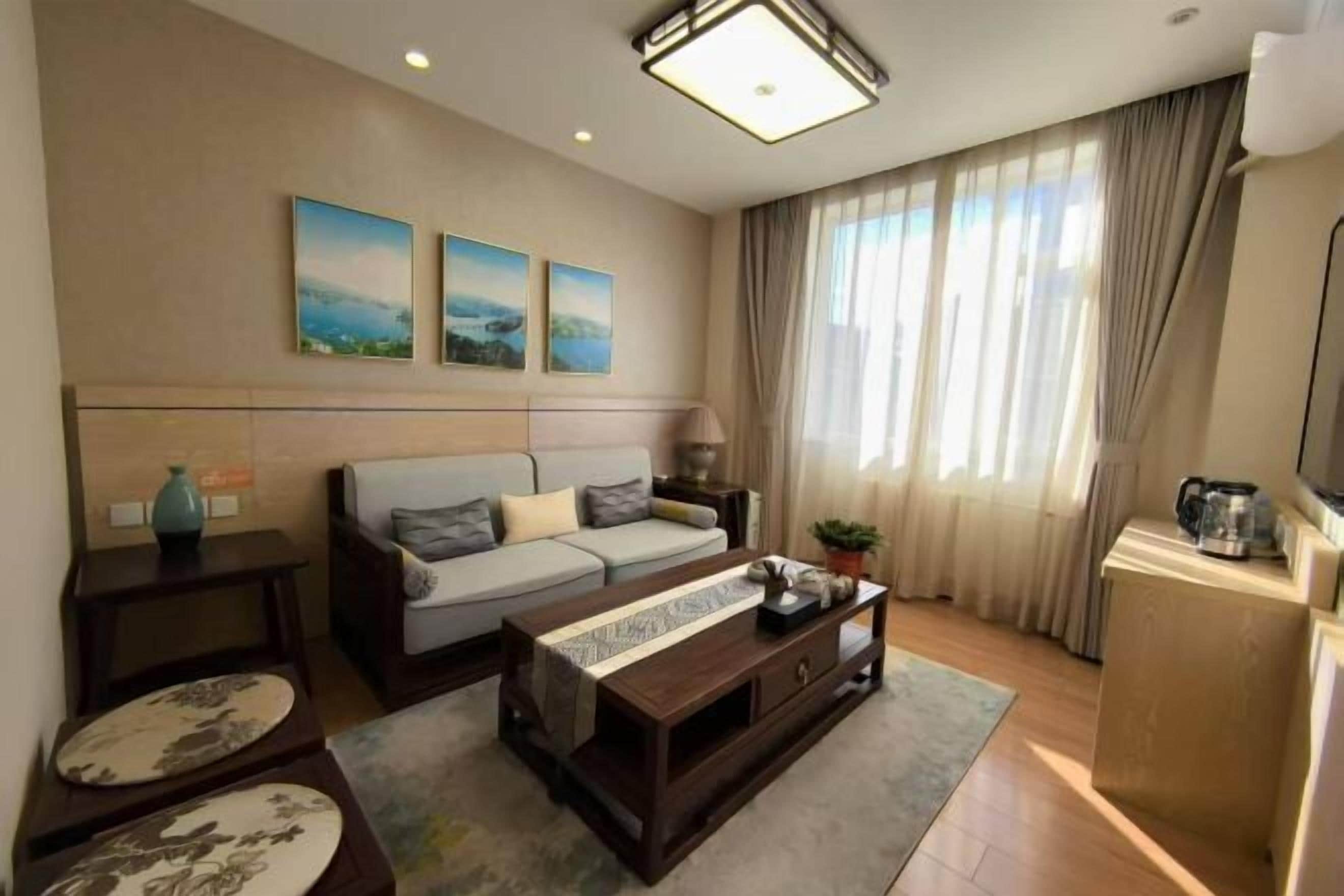 A modern living room with a sofa, coffee table, and artwork on the wall.