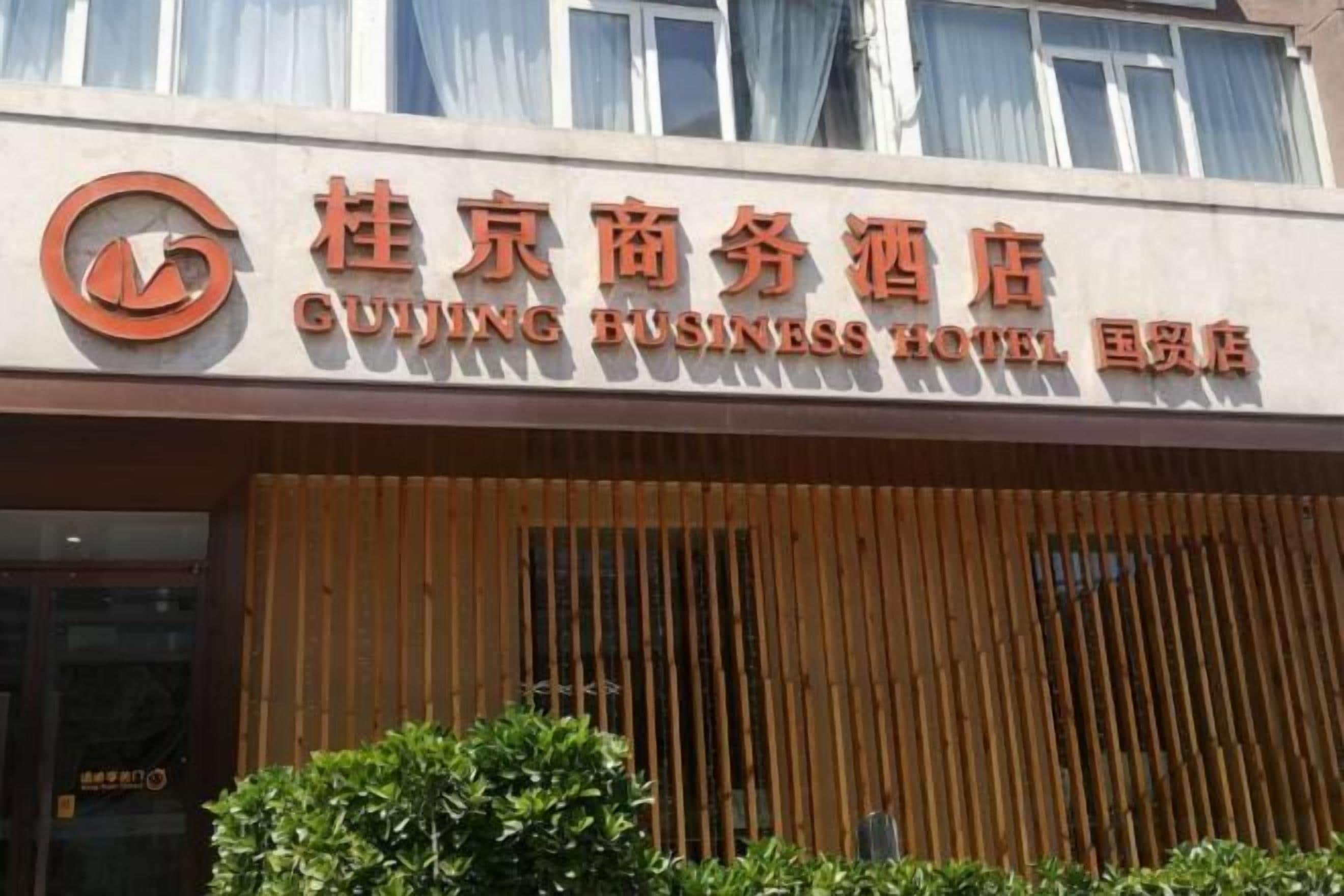 Une enseigne d’hôtel avec des caractères chinois et du texte en anglais.
