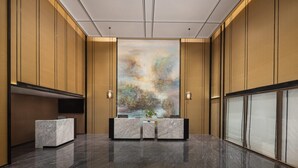 A reception area with a marble reception desk, a large abstract painting on the wall, and a potted plant. - Days lnn by Wyndham Yantai Penglai (Yantai)