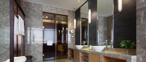 Un baño moderno con un espejo grande, dos lavamanos y un tocador.