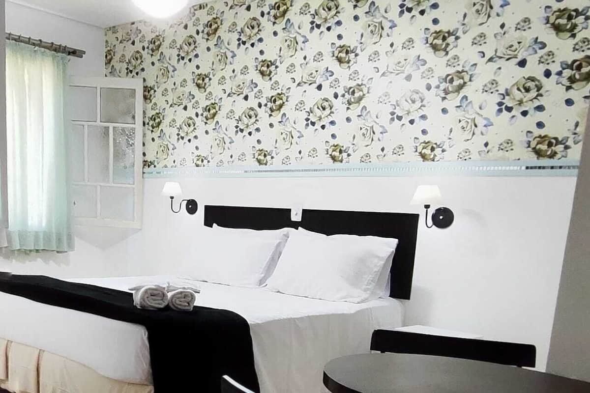 Una habitación con una cama, una mesa redonda y un ventilador de techo.