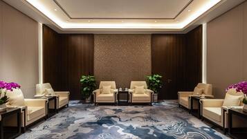 Un vestíbulo de hotel con piso de diseño de mármol, dos sofás y un papel tapiz estampado.