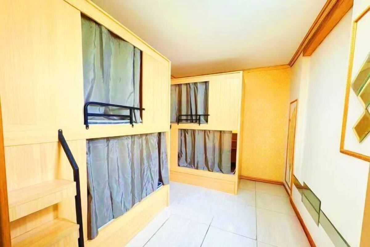 A room with bunk beds, a staircase, and a framed picture on the wall.