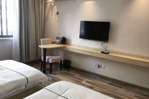A hotel room with two beds, a desk, a chair, a television, and a window with curtains. - Fanhua Hotel (Shanghai)