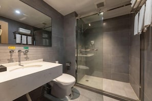 A modern bathroom with a glass-enclosed shower, a white sink, and a toilet. - Fanhua Hotel (Shanghai)