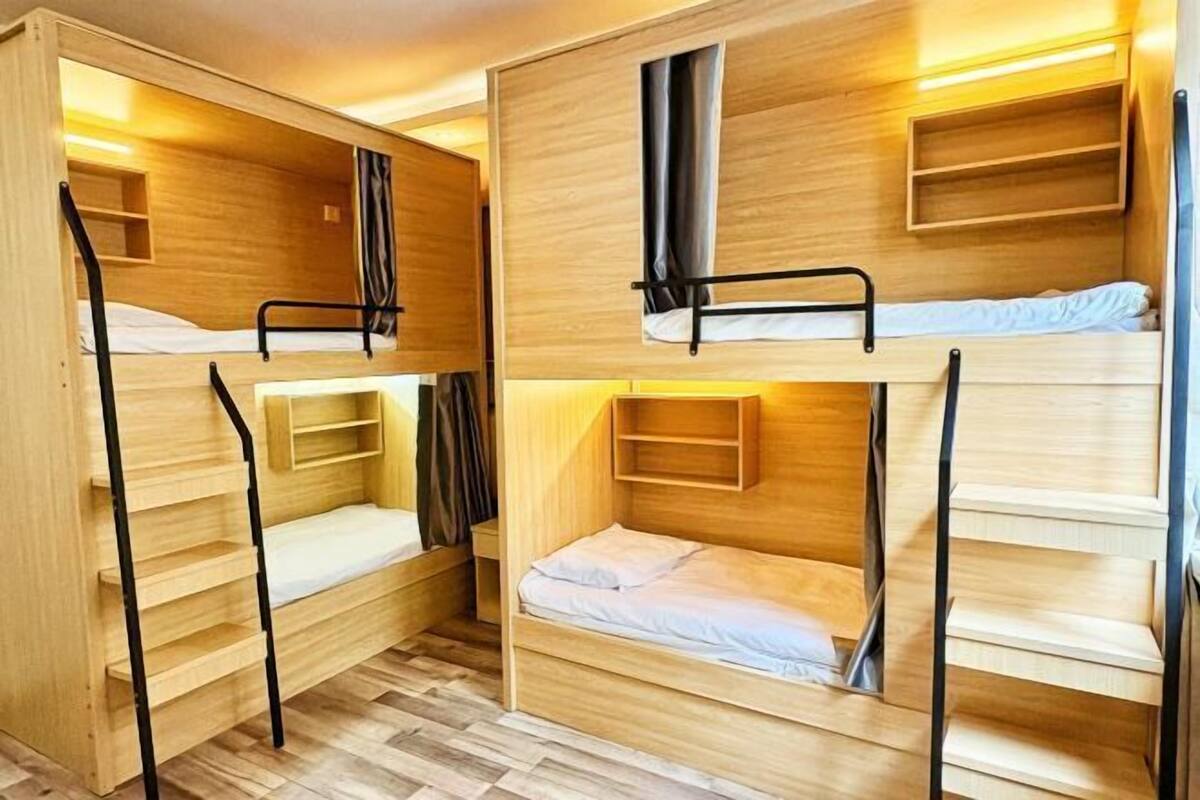 A bunk bed room with wooden walls and built-in shelves.