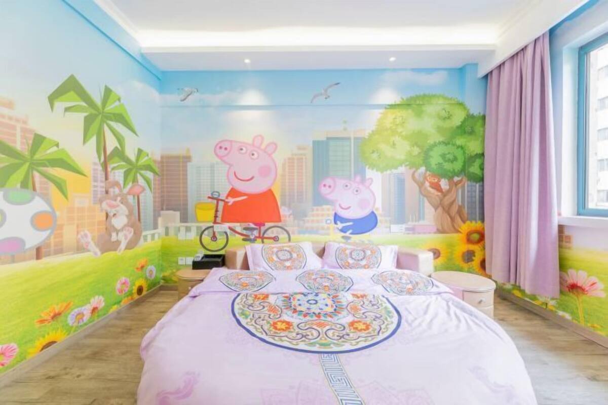 A bedroom with a cityscape mural, a bed with patterned bedding, and a window with curtains.